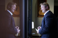 Former U.S. Sen. Dean Heller is reflected in a window at Share Village Las Vegas after announcing a bid for governor of Nevada, Monday, Sept. 20, 2021, in Las Vegas. (AP Photo/John Locher)