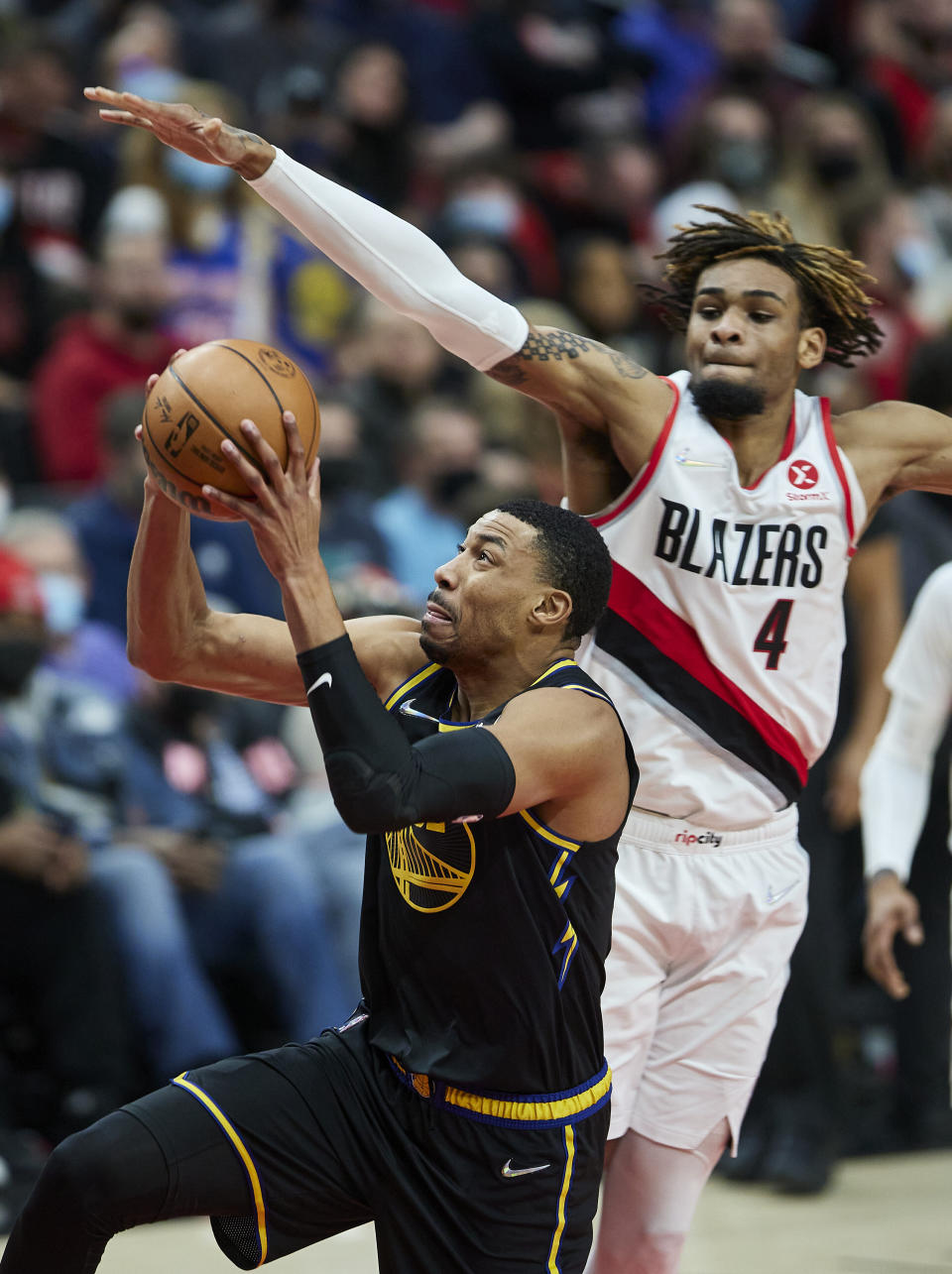 Golden State Warriors forward Otto Porter Jr., left, shoots in front of Portland Trail Blazers forward Greg Brown III during the first half of an NBA basketball game in Portland, Ore., Thursday, Feb. 24, 2022. (AP Photo/Craig Mitchelldyer)
