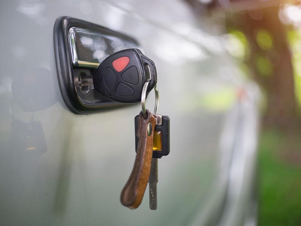 Stock photo of car keys inside side door key hole.