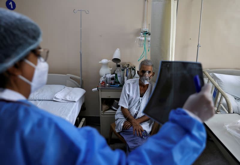 A doctor checks an X-ray of a patient suffering from the coronavirus disease (COVID-19) inside a COVID-19 ward of a hospital in New Delhi