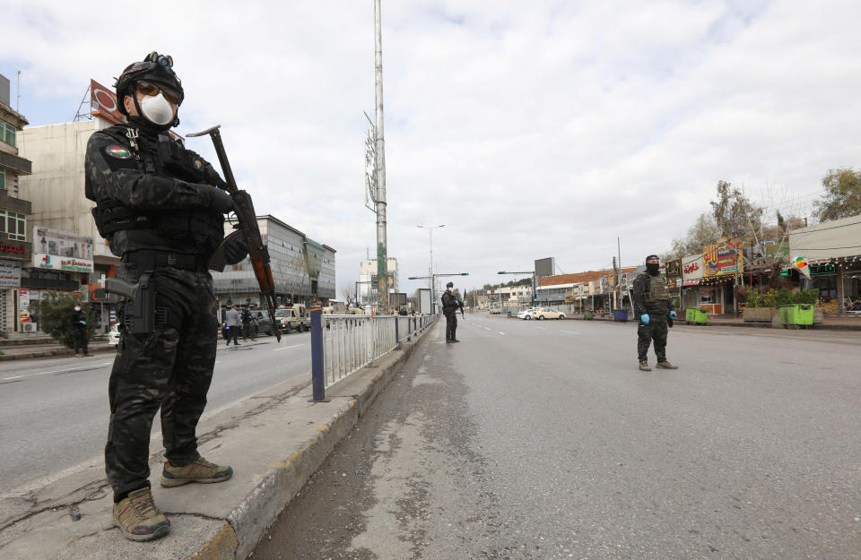 Security men stand in an empty street during a curfew imposed by Iraqi Kurdish authorities, following the outbreak of coronavirus, in Sulaimaniya, in Iraqi Kurdistan, lraq March 14. 2020. REUTERS/Ako Rasheed