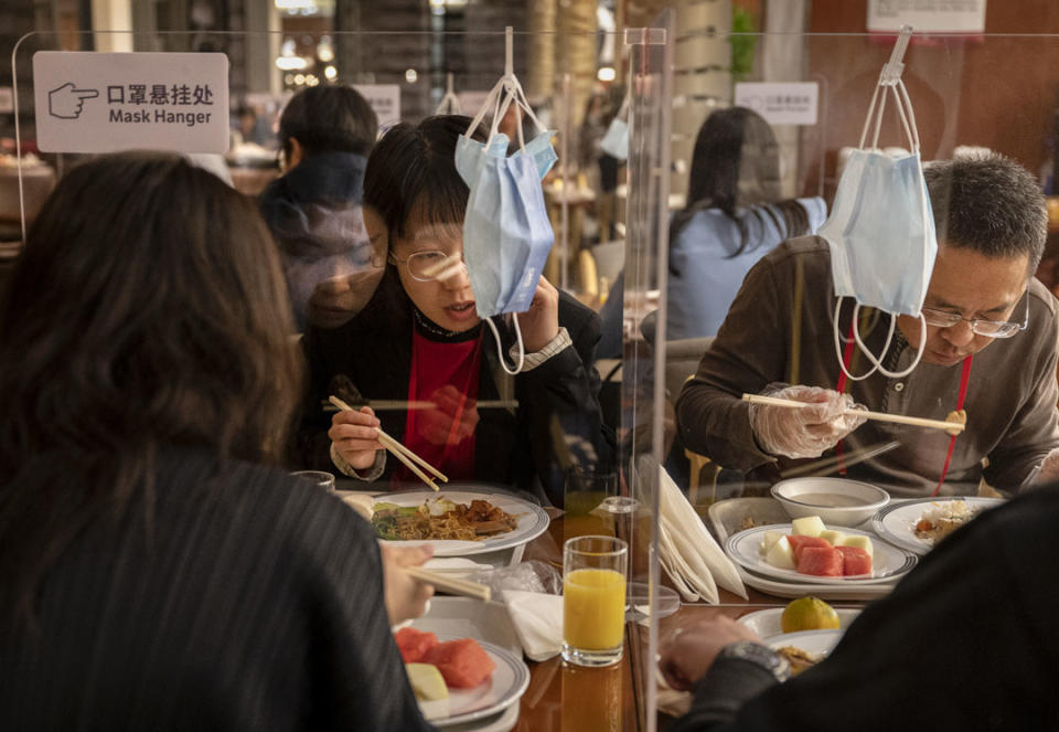 2022年10月14日，為了防止 COVID-19 在北京的傳播，二十大新聞中心的記者在有璃隔隔板的餐桌進餐。