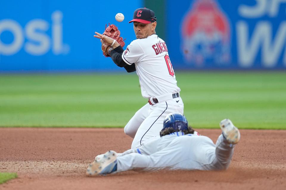 Kansas City Royals' Bobby Witt Jr. slides into second base with a double as Cleveland Guardians second baseman Andres Gimenez bobbles the ball during the fourth inning of a baseball game Friday, July 7, 2023, in Cleveland. (AP Photo/Sue Ogrocki)