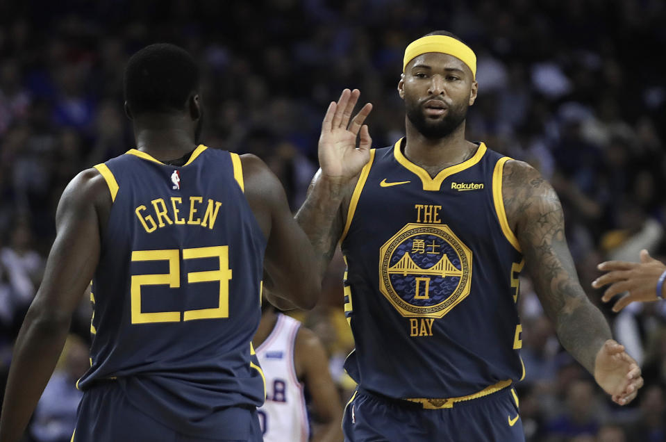 Golden State Warriors' DeMarcus Cousins, right, celebrates a score with Draymond Green (23) during the first half of an NBA basketball game against the Philadelphia 76ers on Thursday, Jan. 31, 2019, in Oakland, Calif. (AP Photo/Ben Margot)