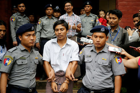 FILE PHOTO: Detained Reuters journalist Kyaw Soe Oo and Wa Lone are escorted by police as they leave after a court hearing in Yangon, Myanmar, August 20, 2018. REUTERS/Ann Wang/File Photo
