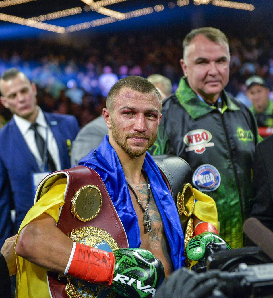 Vasiliy Lomachenko poses with the belts after defeating Jose Pedraza in the WBO title lightweight boxing match at Madison Square Garden, Saturday, Dec. 8, 2018, in New York. (AP Photo/Howard Simmons)