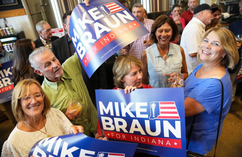 Sen. Mike Braun supporters smile with posters Tuesday, May 7, 2024, during a watch party at Moontown Brewery in Whitestown.