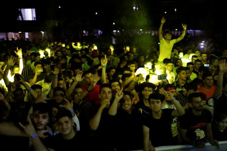 Young people dance and cheer as they attend electronic music concert with western tunes at closed Hall in Shaab Stadium for the first time in Baghdad