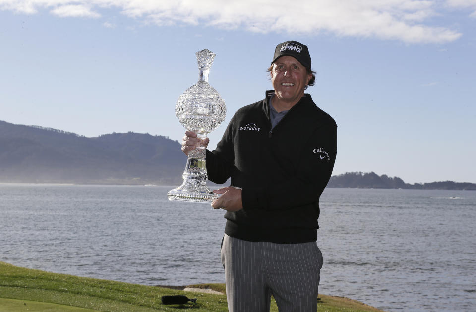 Phil Mickelson poses with his trophy on the 18th green of the Pebble Beach Golf Links after winning the AT&T Pebble Beach Pro-Am golf tournament Monday, Feb. 11, 2019, in Pebble Beach, Calif. (AP Photo/Eric Risberg)
