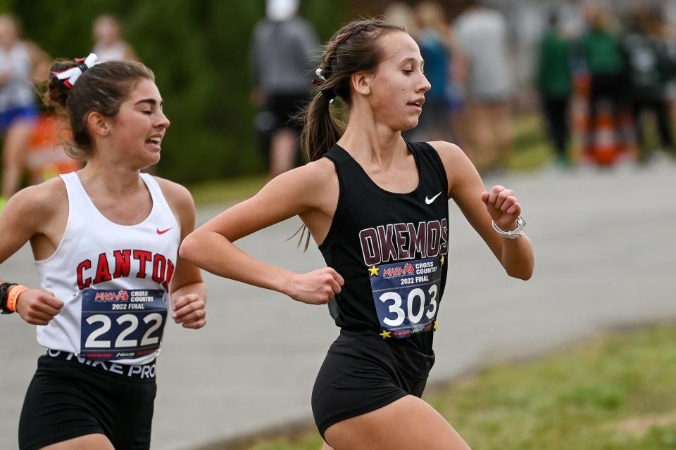 Okemos' Shannon Gillahan, right, runs in front of Canton's Cara Newman during the Division 1 girls state cross country final on Saturday, Nov. 5, 2022, at Michigan International Speedway in Brooklyn.