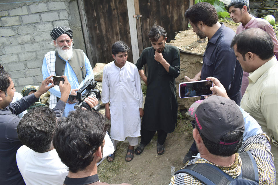 Gul Faraz, center right, and Rizwan Ullah, center left, survivors of cable car incident, talk to members of media, at near the incident site, in Pashto village, a mountainous area of Battagram district in Pakistan's Khyber Pakhtunkhwa province, Wednesday, Aug. 23, 2023. The rescue of six school children and two adults who were plucked from a broken cable car that was dangling precariously hundreds of meters (yards) above a steep gorge was a miracle, a survivor said Wednesday. The teenager said he and the others felt repeatedly that death was imminent during the 16-hour ordeal. (AP Photo/Saqib Manzoor)
