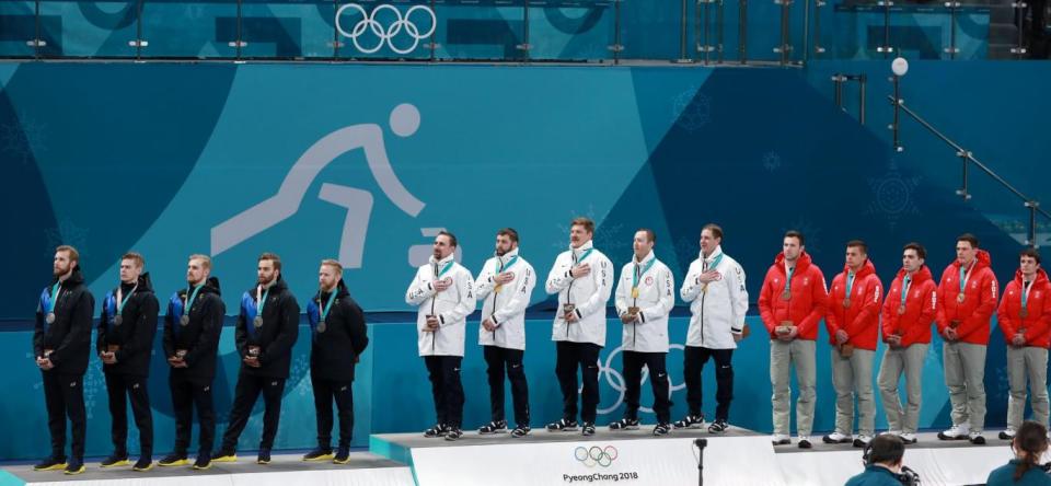 The USA, Sweden and Switzerland curling teams receive their medals (EPA)