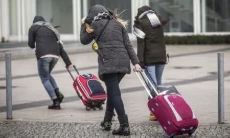 Tourists search for shelter as Storm Niklas strikes in Berlin March 31, 2015. One of the strongest storm fronts in years hit Germany on Tuesday, as Storm Niklas uncovered roofs, toppled scaffolding and caused severe disruption to rail services. REUTERS/Hannibal Hanschke