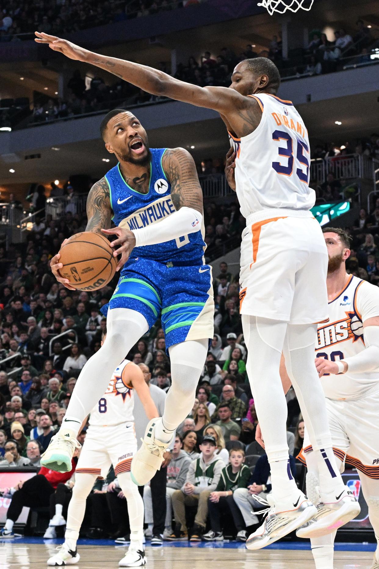 Milwaukee Bucks guard Damian Lillard drives to the basket against Phoenix Suns forward Kevin Durant during a March 17, 2024, game at Fiserv Forum.