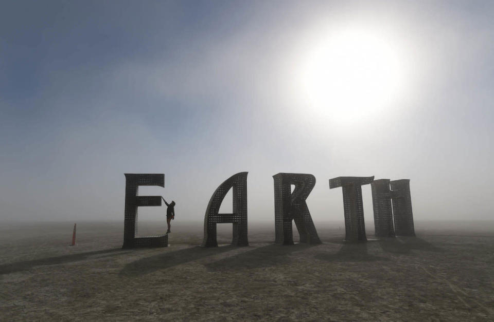 <p>Anita Vranckx, of Belgium, hangs from the E of an Earth sculpture at Burning Man on a dusty morning on the playa in the Black Rock Desert near Gerlach, Nev., on Saturday Aug. 27, 2016. The annual festival is dedicated to community, art, self-expression and self-reliance. (Andy Barron/The Reno Gazette-Journal via AP)</p>