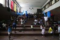 Displaced families victims of Cyclone Idai, eat lunch at the Samora Machel Secondary School which is being used to house victims of the floods in Beira, Mozambique, Sunday March 24, 2019. The death toll has risen above 750 in the three southern African countries hit 10 days ago by the cyclone storm, as workers restore electricity, water and try to prevent outbreak of cholera, authorities said Sunday. (AP Photo/Phill Magakoe)