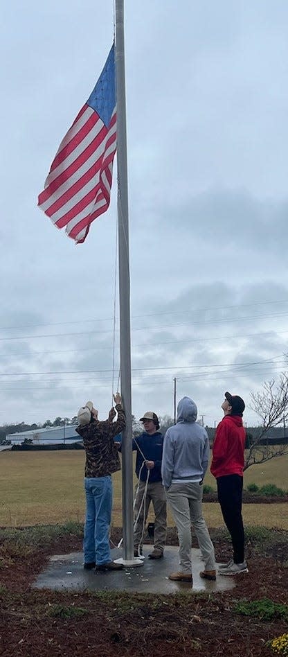 Classmates of 17-year-old Thomas Jefferson County junior Carter Gay, who was killed in an accidental shooting on his family's farm Thursday, Feb. 29, lower the flag to half mast in memory and honor of their friend Friday morning.