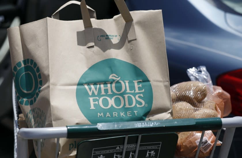 FILE - In this Friday, June 16, 2017, file photo, groceries from Whole Foods Market sit in a cart be
