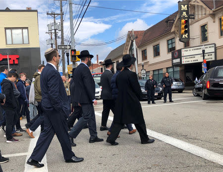 Mourners follow the hearse on foot after the funeral of Tree of Life Synagogue shooting victim Jerry Rabinowitz in Pittsburgh, Pennsylvania, U.S. October 30, 2018. The sign on the movie theater at right reads "PGH is stronger than hate". REUTERS/Jessica Resnick-Ault