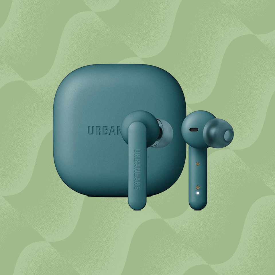 the urbanears alby wireless earbuds in teal against a wavy green background