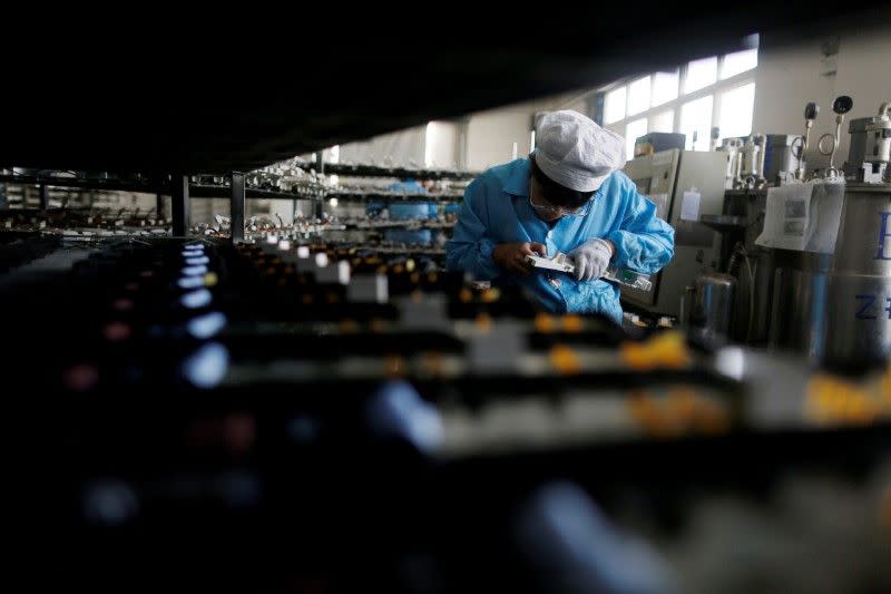 A labourer works inside an electronics factory in Qingdao, Shandong province in China January 29, 2018. ― Reuters pic