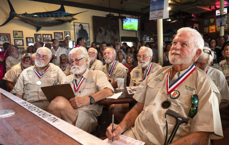 In this photo provided by the Florida Keys News Bureau, Tom Grizzard, right, winner of the 2008 "Papa" Hemingway Look-Alike Contest, and other past winners judge contestants during the 2023 contest, Thursday, July 20, 2023, at Sloppy Joe's Bar in Key West. Almost 140 contestants are competing in the challenge, a featured event of Key West's annual Hemingway Days festival that ends Sunday, July 23. Hemingway's 124th birthday anniversary is Friday, July 21. The 2023 "Papa" is to be crowned Saturday, July 22. (Andy Newman/Florida Keys News Bureau via AP)