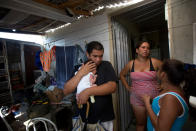 <p>Rafaela Silva dos Santos talks while her husband Marcio Enrique holds their baby Sofia Valentina in their home at the Vila Autodromo slum, in Rio de Janeiro, Brazil, Wednesday, March 9, 2016. Both Santos and her husband say they have been assaulted by the municipal guards who often patrol the area. They have also received anonymous phone calls telling them to leave. Vila Autodromo has now been largely destroyed to make way for an access route into the Olympic Park. (AP Photo/Silvia Izquierdo)</p>