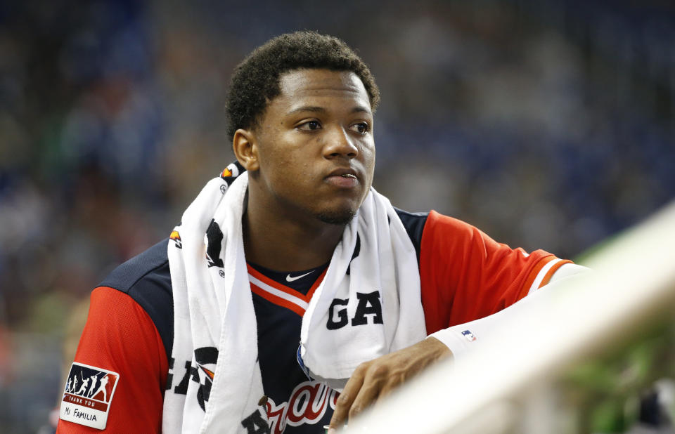 In this Aug. 26, 2018 photo Atlanta Braves left fielder Ronald Acuna Jr. looks out of the dugout during the fourth inning of a baseball game against the Miami Marlins in Miami. Acuna Jr. was a runaway pick for the NL Rookie of the Year over Washington outfielder Juan Soto in a contest between 20-year-olds. He received 27 first-place votes and three seconds for 144 points. (AP Photo/Wilfredo Lee)