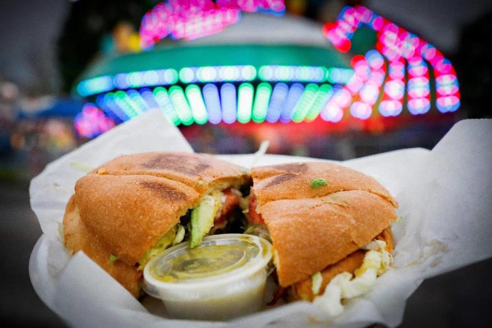 A torta made with seasoned pork, mozzarella cheese, onion, lettuce, tomato, avocado slices and served with a side of green sauce at Taqueria De La Cruz at the Lexington Lions Club’s Bluegrass Fair at Masterson Station Park in Lexington, Ky., Friday, June 11, 2021.