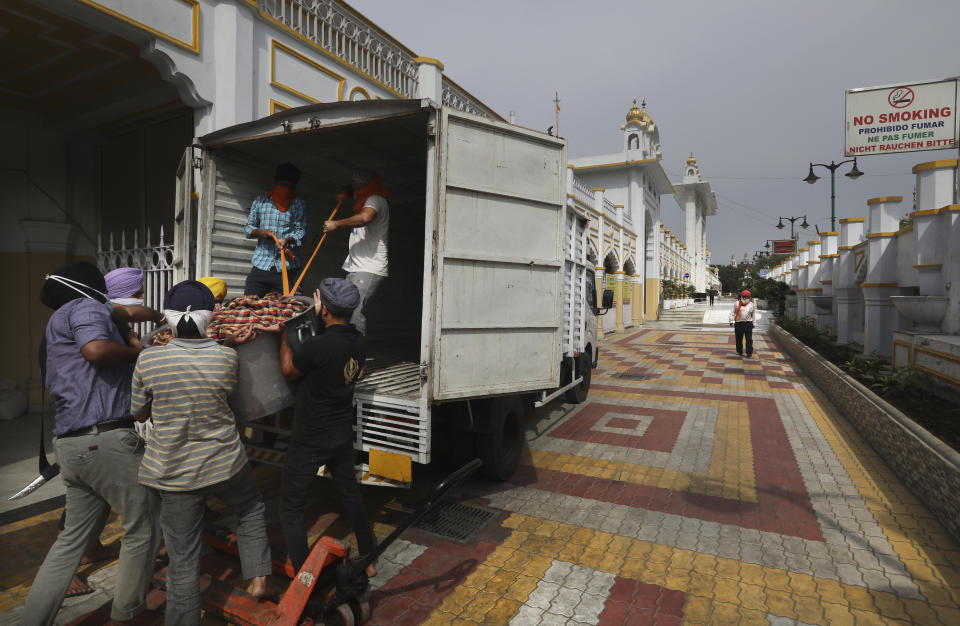 Sikh volunteers help to load food in a van from the kitchen hall of the Bangla Sahib Gurdwara for distribution, in New Delhi, India, Sunday, May 10, 2020. The Bangla Sahib Gurdwara has remained open through wars and plagues, serving thousands of people simple vegetarian food. During India's ongoing coronavirus lockdown about four dozen men have kept the temple's kitchen open, cooking up to 100,000 meals a day that the New Delhi government distributes at shelters and drop-off points throughout the city. (AP Photo/Manish Swarup)