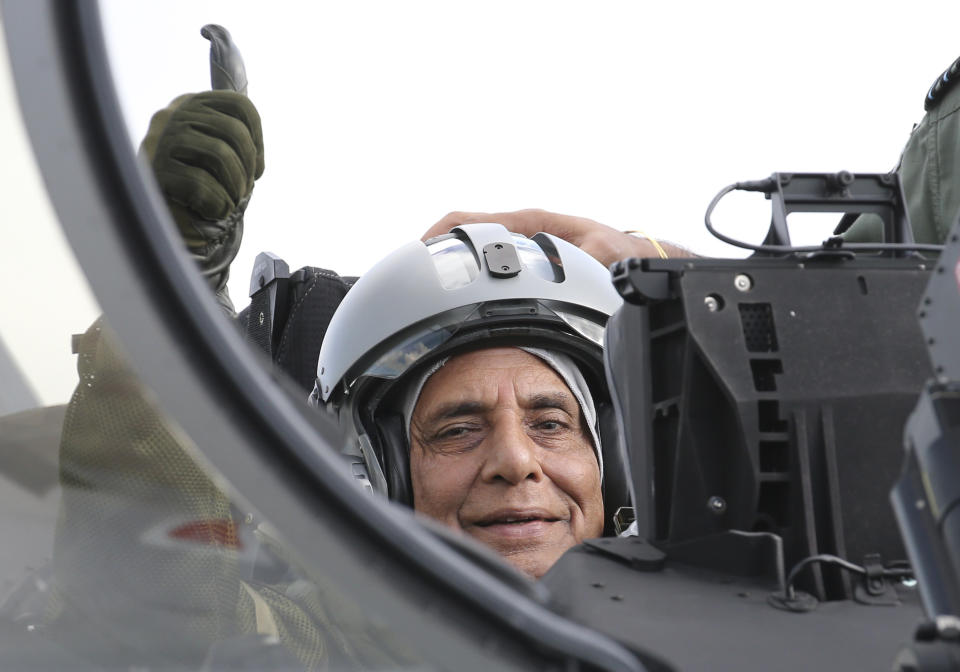 Indian Defense Minister Rajnath Singh thumbs up as he sits in a Rafale jet fighter during an handover ceremony at the Dassault Aviation plant in Merignac, near Bordeaux, southwestern France, Tuesday, Oct. 8, 2019. France has delivered to India its first Rafale fighter jet from a series of 36 aircraft purchased in a multi-billion dollar deal in 2016. (AP Photo/Bob Edme)