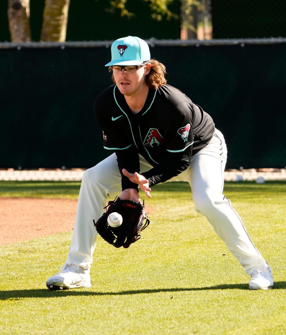 Arizona Diamondbacks pitcher Andrew Saalfrank (27) fields a ground ball during spring training workouts at Salt River Fields at Talking Stick in Scottsdale on Feb. 15, 2024.