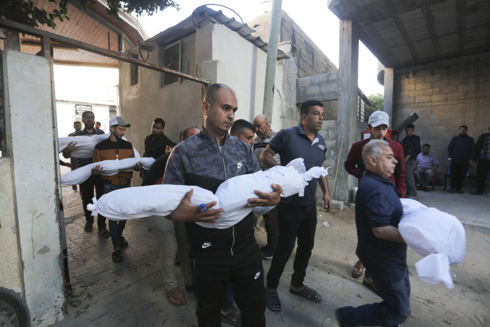 Palestinos trasladan los cuerpos de la familia Hijazi, asesinados en un ataque israelí en Rafah, en la Franja de Gaza, el 31 de octubre de 2023. (AP Foto/Hatem Ali)