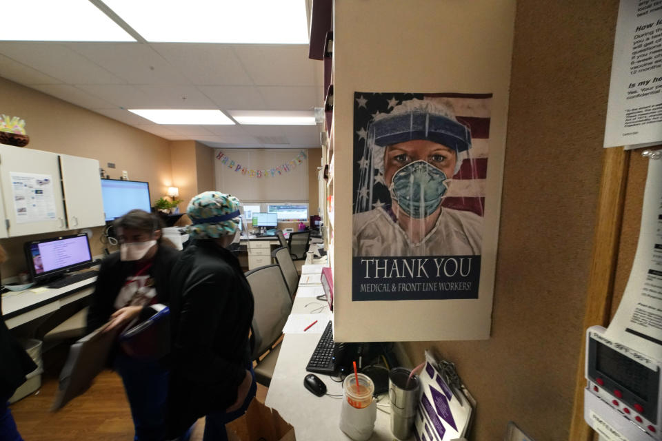 A poster honoring medical and frontline workers, hangs on a nursing station of an intensive care unit, at the Willis-Knighton Medical Center in Shreveport, La., Wednesday, Aug. 18, 2021. (AP Photo/Gerald Herbert)