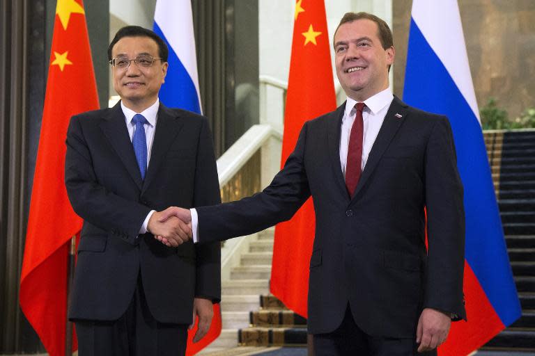 Russia's Prime Minister Dmitry Medvedev (R) welcomes China's Prime Minister Li Keqiang before a meeting in Moscow, on October 13, 2014