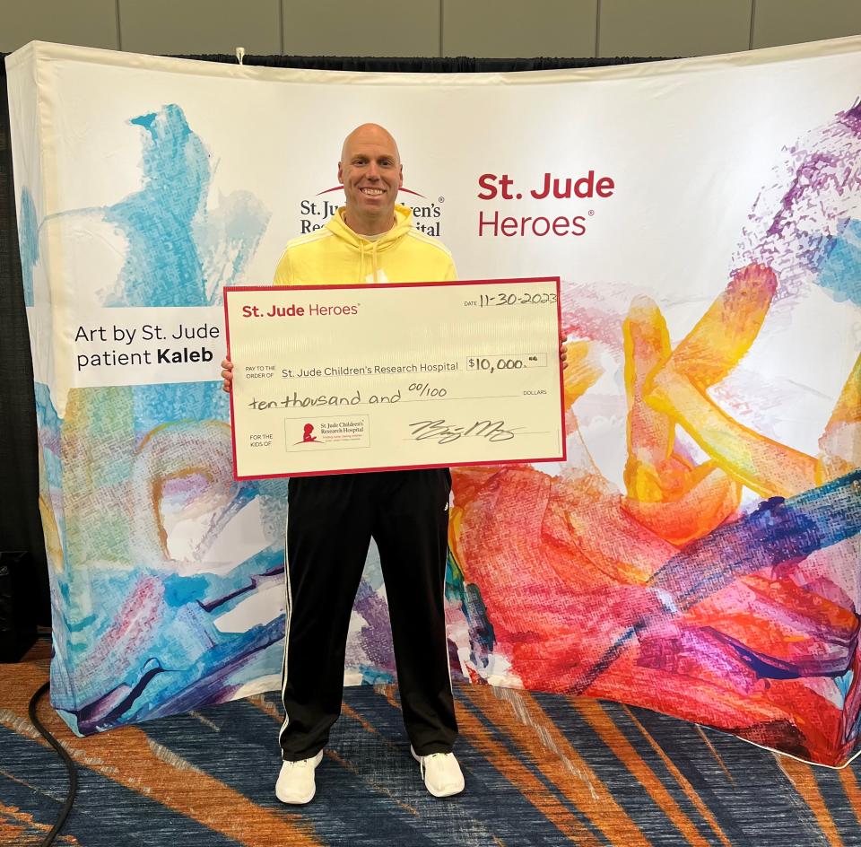 Bryant Mosbey, a physical education teacher at Thompkins Middle School presented a check for $10,000 after running a half-marathon at St. Jude Marathon Weekend in Memphis earlier this month.