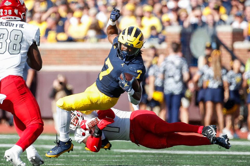 Michigan running back Donovan Edwards (7) runs for a first down against UNLV defensive back Jerrae Williams (1) during the first half at Michigan Stadium in Ann Arbor on Saturday, Sept. 9, 2023.