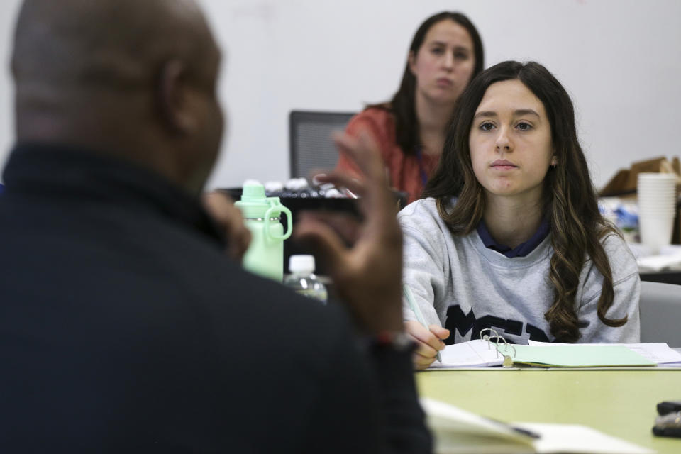 Sydney Yost takes notes as Troy Vincent, NFL Executive Vice President of Football Operations, left, talks with members of the "Flag Football United" initiative group at Mount St. Mary Academy on Wednesday, Jan. 18, 2023, in Kenmore, N.Y. (AP Photo/Joshua Bessex)