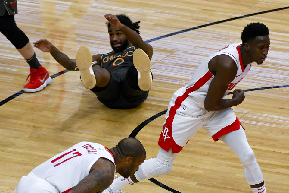 Chicago Bulls guard Coby White (0) lays on the ground after fighting for the ball with the ball against Houston Rockets guard Victor Oladipo, right, and forward P.J. Tucker (17) during the first half of an NBA basketball game Monday, Jan. 18, 2021, in Chicago. (AP Photo/Matt Marton)