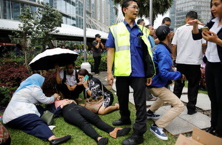 Injured people are treated outside the Indonesian Stock Exchange building following reports of a collapsed structure inside the building in Jakarta, Indonesia January 15, 2018. REUTERS/Darren Whiteside