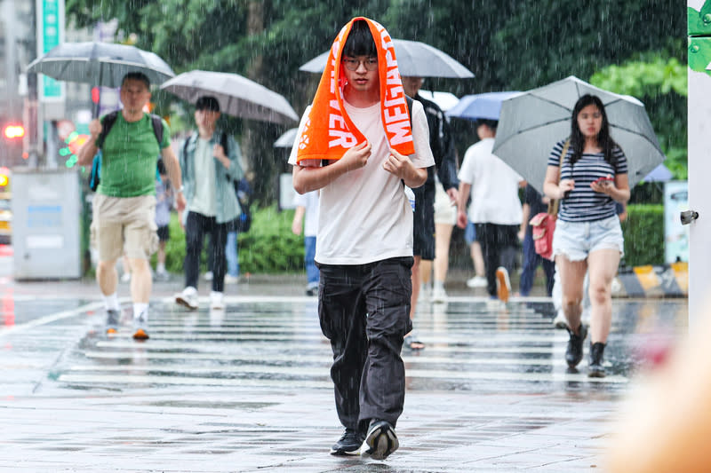 鋒面通過　台北陣雨（1） 中央氣象署1日表示，受到鋒面通過影響，各地易有 對流性降雨出現，台北市午後降下陣雨，有行人披著 毛巾穿越馬路。 中央社記者鄭清元攝  113年5月1日 