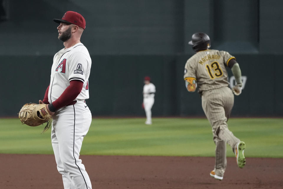 San Diego Padres' Manny Machado (13) rounds the bases after hitting a two run home run as Arizona Diamondbacks first baseman Christian Walker, left, pauses at first base during the fifth inning of a baseball game Friday, May 3, 2024, in Phoenix. (AP Photo/Ross D. Franklin)