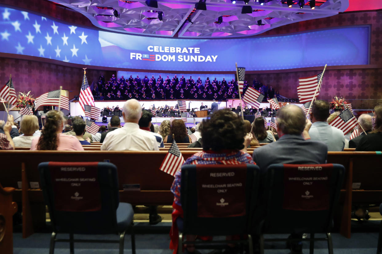 Attendees wave flags as music is played before Vice President Mike Pence made comments at First Baptist Church Dallas during a Celebrate Freedom Rally in Dallas, Sunday, June 28, 2020. (AP Photo/Tony Gutierrez)