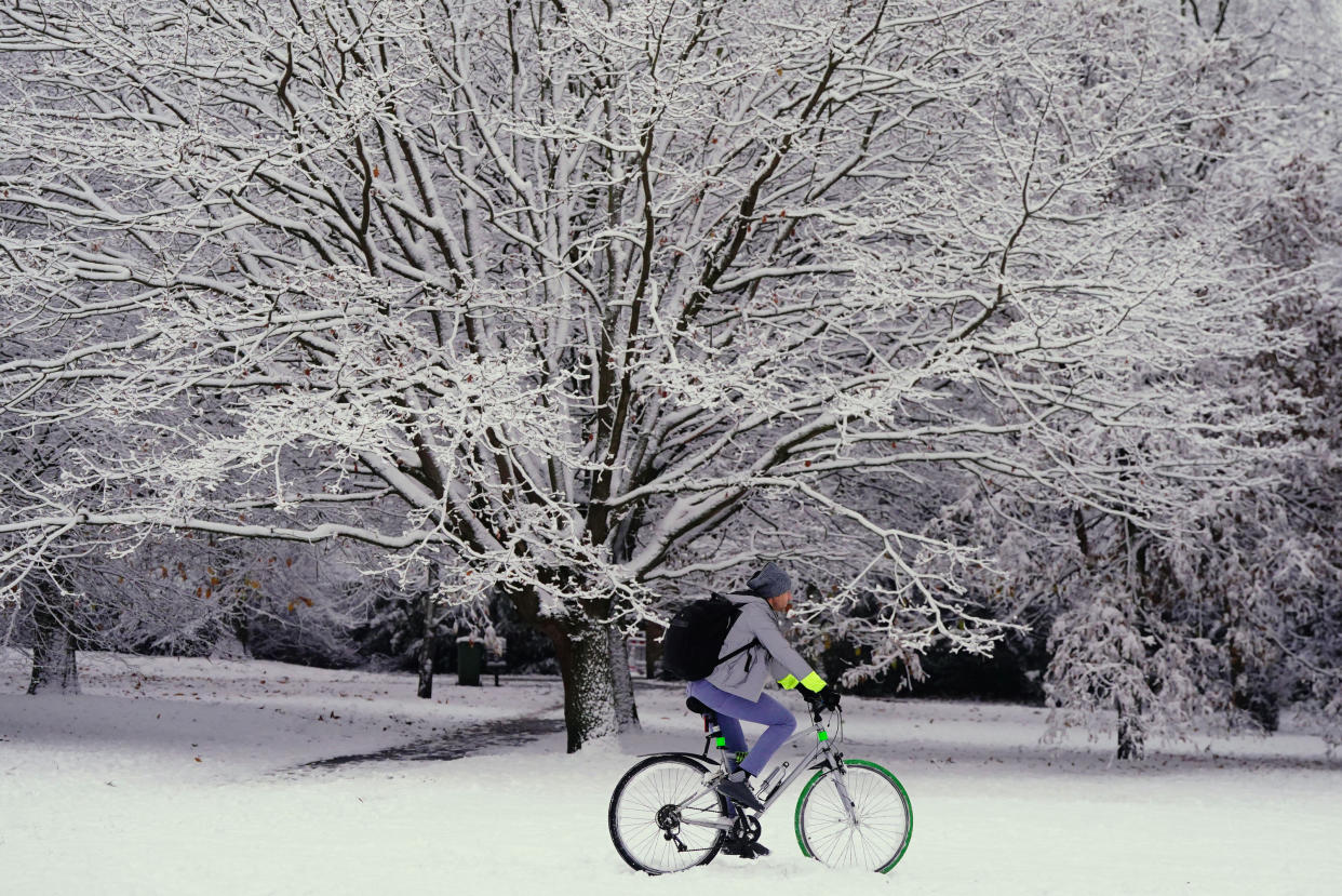 A person cycles through the snow in Greenwich Park, London. Snow and ice have swept across parts of the UK, with cold wintry conditions set to continue for days. Picture date: Monday December 12, 2022.
