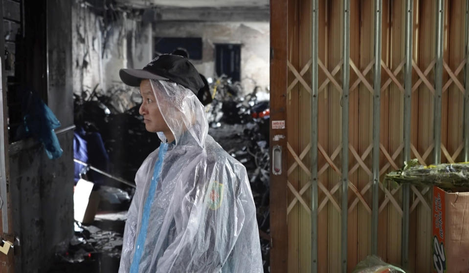 A security officer guards the entrance of an apartment building that was caught on fire in Hanoi, Vietnam Thursday, Sept. 14, 2023. A fire broke just before midnight Tuesday in the apartment building that killed scores of people. (AP Photo/Hau Dinh)