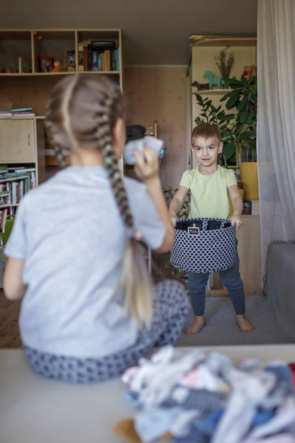 rear view of sister throwing clothes in bucket fun activities for kids