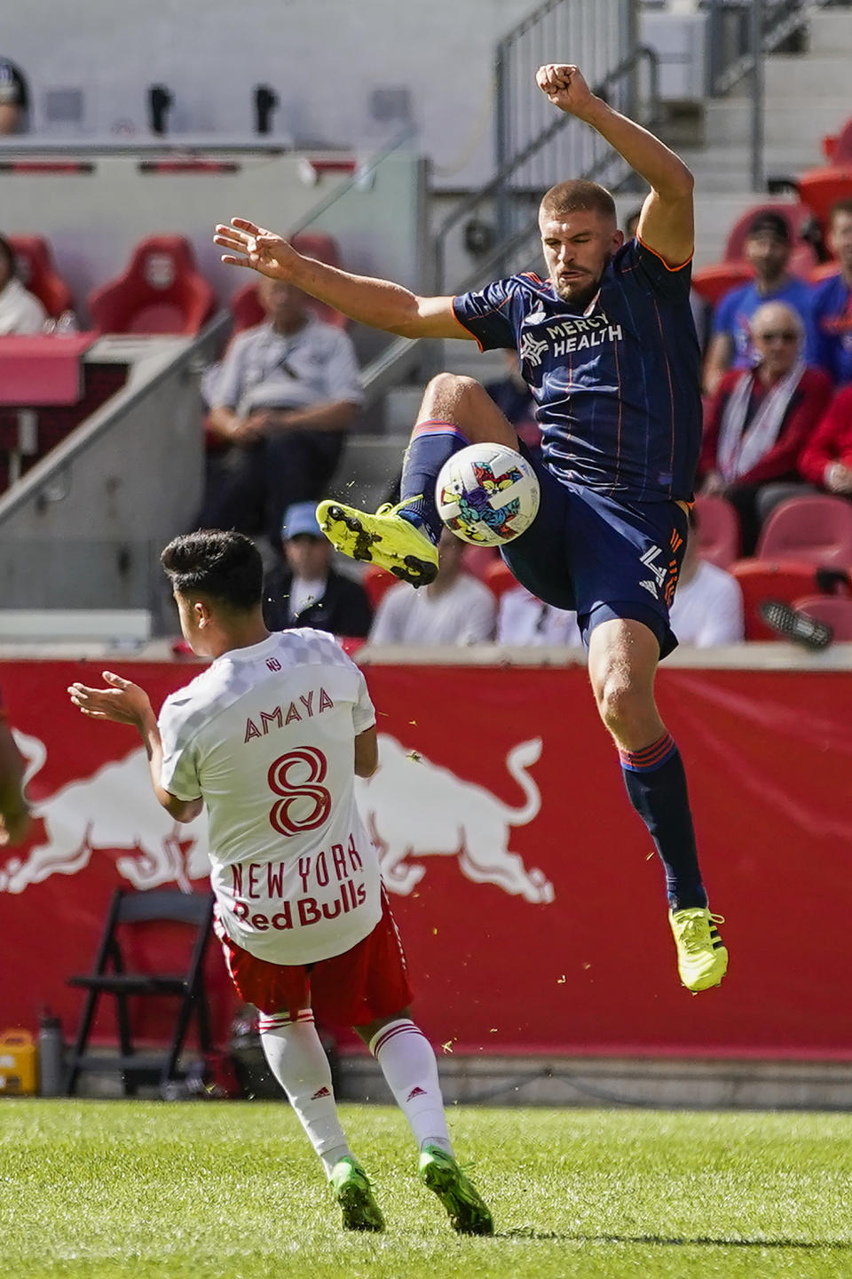 El defensor del FC Cincinnati Nick Hagglund (4) salta para quedarse con el balón frente a Frankie Amaya de Red Bulls en partido de playoffs de la MLS en Harrison, Nueva Jersey, sábado 15 de octubre de 2022. Cincinnati ganó 2-1. (AP Foto/Eduardo Munoz Alvarez)