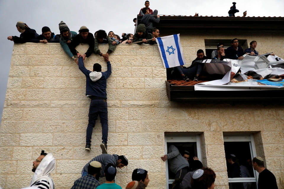 <p>A pro-settlement activist climbs onto a rooftop of a house to resist evacuation of some houses in the settlement of Ofra in the occupied West Bank, during an eviction operation by Israeli forces, Feb. 28, 2017. (Ronen Zvulun/Reuters) </p>