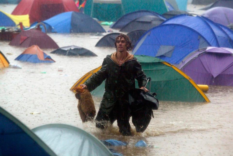 A festival-goer tries to rescue belongings washed away in 2005 (Getty Images)