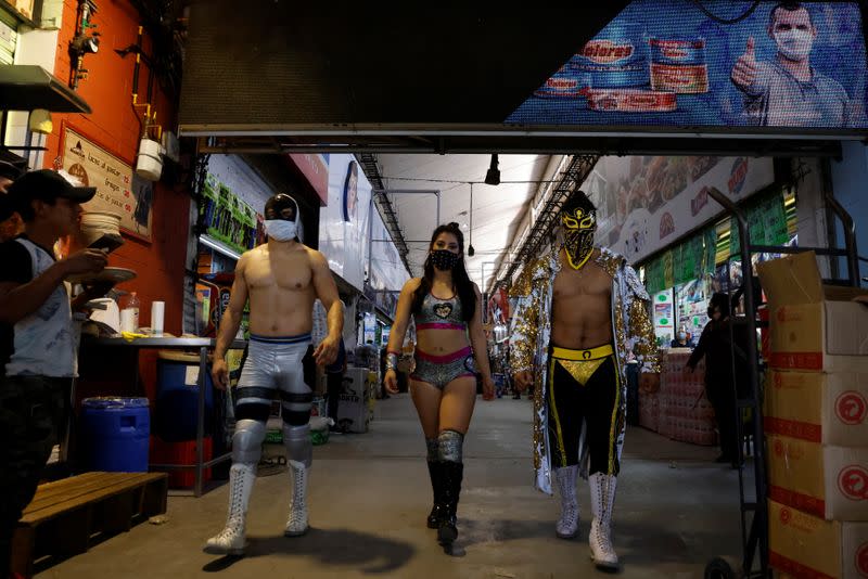 Lucha libre wrestlers arrive to encourage mask-less people to wear masks to aid the prevention against the continued coronavirus disease (COVID-19) at the Central Abastos market, in Mexico City